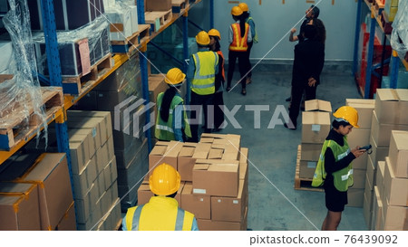 Many people , workers and manger work in warehouse or storehouse Many people , workers and manger work in warehouse or storehouse 76439092