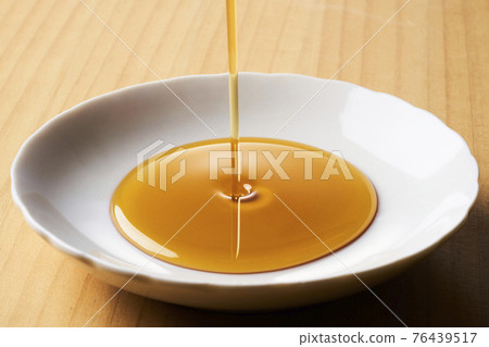Sesame oil on the plate 76439517