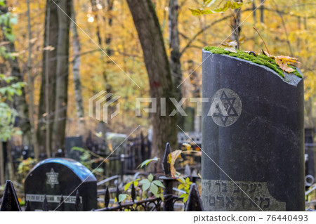 old round gravestone in a jewish cemetery with painted six pointed star. traditional jewish sign David star, David shield old round gravestone in a jewish cemetery with painted six pointed star. traditional jewish sign David star, David shield 76440493