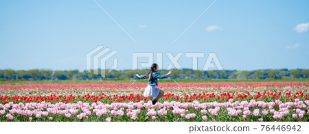 Girl playing in a flower field Girl playing in a flower field 76446942
