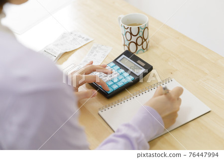 拿著家庭帳簿的婦女 76447994