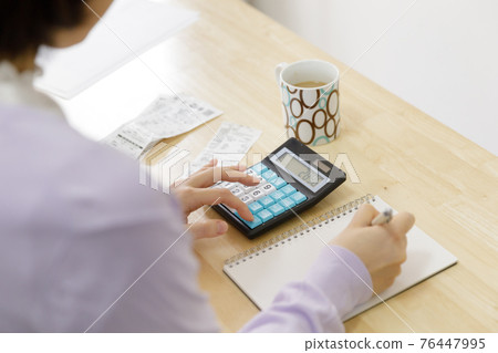 拿著家庭帳簿的婦女 76447995