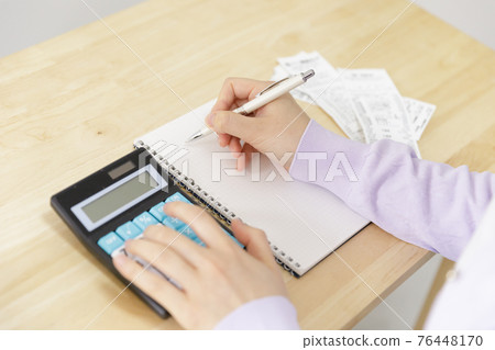 A woman holding a household account book 76448170