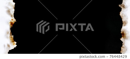 Dark banner of burnt torn paper frame on black background 76448429