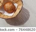 Sunny Breadbasket with long shadow on white wooden table top view. Closeup Bun in basket modern banner snack food decorative design with copy space. Bright Corner bakery flat lay horizontal concept 76448620