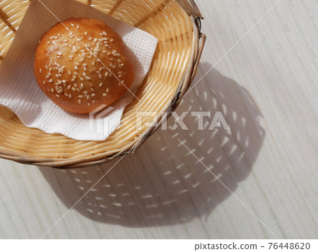 Sunny Breadbasket with long shadow on white wooden table top view. Closeup Bun in basket modern banner snack food decorative design with copy space. Bright Corner bakery flat lay horizontal concept 76448620