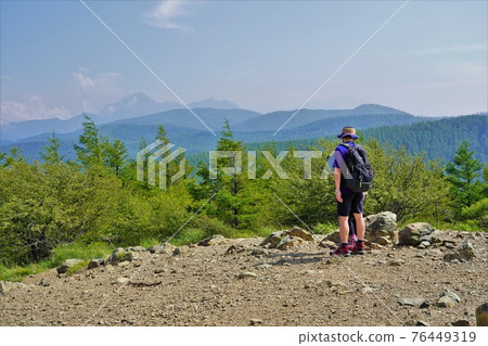 從入笠山山頂眺望海駒山和野木切山的登山者 76449319