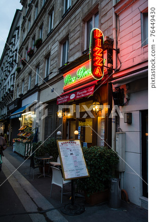 Parisian skyline at sunset, a small pizza restaurant with neon lights 76449430