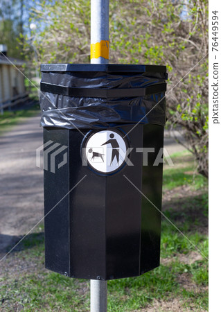 Close up of a bin specifically used for disposing of dog waste conceptualising. Dog poo waste litter bin. Close up of a bin specifically used for disposing of dog waste conceptualising. Dog poo waste litter bin. 76449594