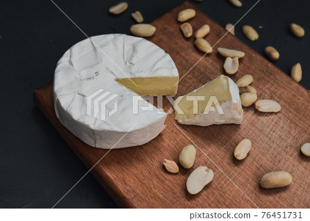 cheese camembert with mold and nuts on wooden board 76451731