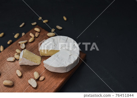 cheese camembert with mold and nuts on wooden board 76451844