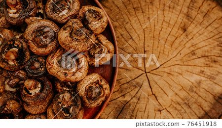 Cooked mushrooms lie on a brown clay plate on a cracked hemp Cooked mushrooms lie on a brown clay plate on a cracked hemp 76451918