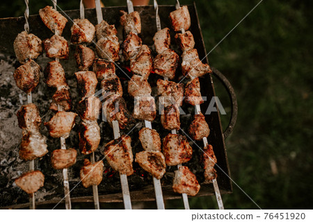 Pork veal cow meat cut into square pieces and fried over a fire Pork veal cow meat cut into square pieces and fried over a fire 76451920