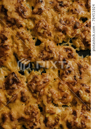 Meat cheese pizza. Baked meat in the oven lies on a black metal baking sheet 76451924