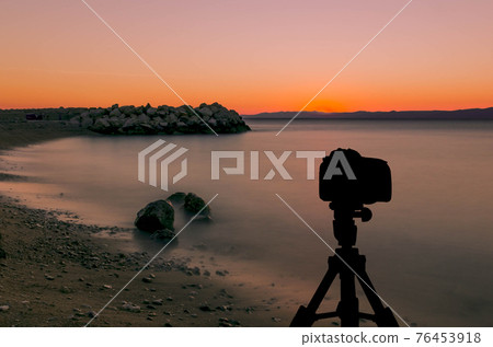 Camera on tripod with sunset over Adriatic Sea Camera on tripod with sunset over Adriatic Sea 76453918