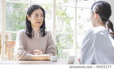 Two women talking at home 76455177