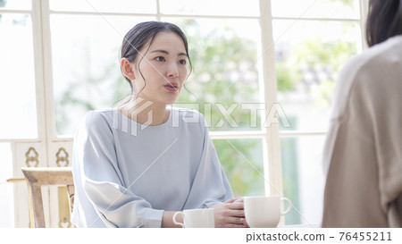 Two women talking at home Two women talking at home 76455211