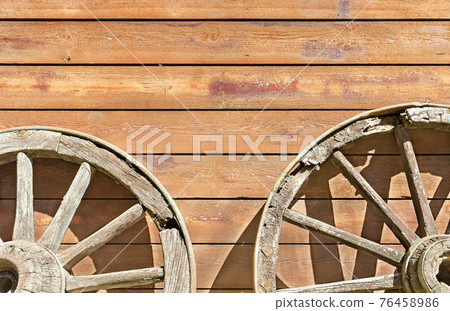 wheels from a cart on a background of a wooden wall 76458986