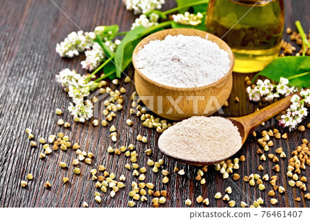 Flour buckwheat brown in spoon with oil on dark board 76461407