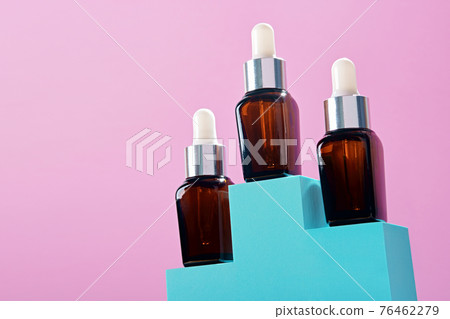 Three Beauty natural skincare product. Serum or Collagen Dropper Bottles on on pedestal for branding and packaging presentation 76462279