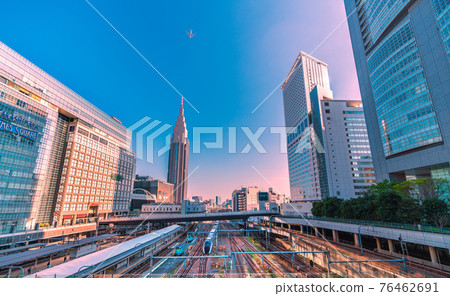 View of Tokyo cityscape of Japan, such as NTT Docomo Yoyogi Building and limited express. Aircraft in the sky View of Tokyo cityscape of Japan, such as NTT Docomo Yoyogi Building and limited express. Aircraft in the sky 76462691