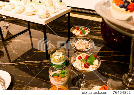 Wedding snacks at the candy bar, sweets and fruit. 76464891