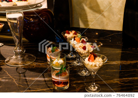 Wedding snacks at the candy bar, sweets and fruit. 76464892