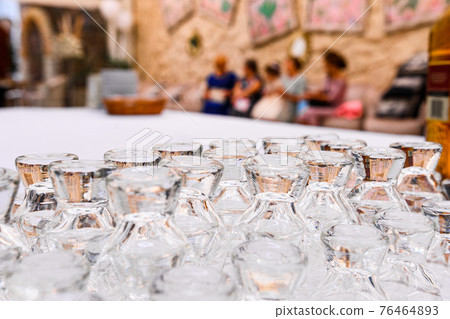 a set of glasses for drinking, glasses in a row and top upside down. 76464893