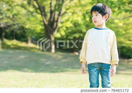 Boy playing in a park rich in nature 76465172