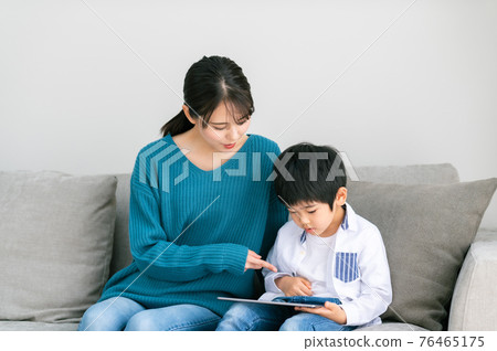 坐在沙發上，看到平板電腦的親子 76465175