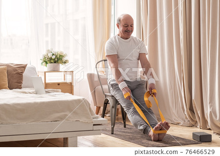 Man sitting on chair doing paschimottanasana or Intense Dorsal Stretch pose Man sitting on chair doing paschimottanasana or Intense Dorsal Stretch pose 76466529