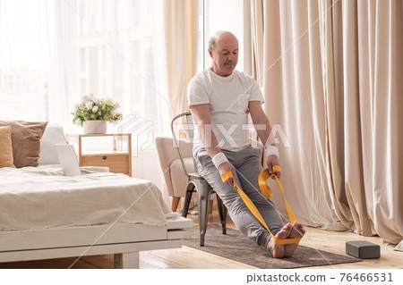 Man sitting on chair doing paschimottanasana or Intense Dorsal Stretch pose Man sitting on chair doing paschimottanasana or Intense Dorsal Stretch pose 76466531