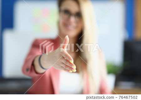 Businesswoman stretches out her hand for handshake Businesswoman stretches out her hand for handshake 76467502