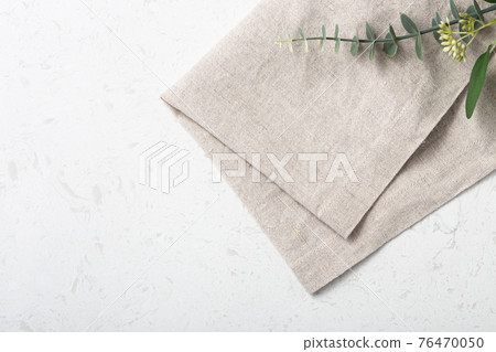 Folded linen napkin on marble table Folded linen napkin on marble table 76470050