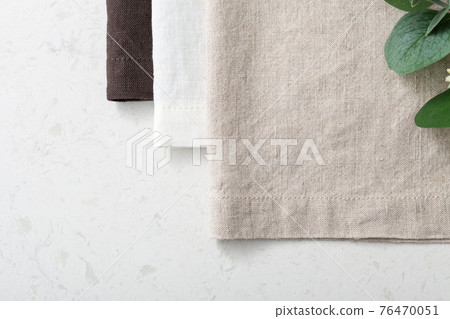 Linen napkin with green plant on marble table 76470051