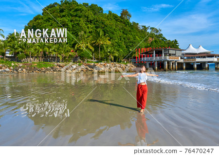 happy tourist woman enjoy travel on the central beach in Langkawi tropical island 76470247