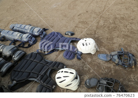 Baseball equipment such as catcher protectors lined up on the soil ground Baseball equipment such as catcher protectors lined up on the soil ground 76470623