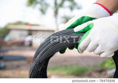 Workers hold steel wire 76470896