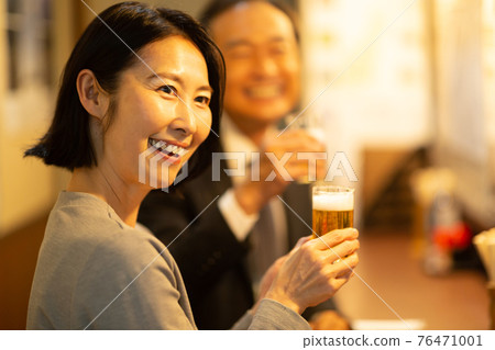 A man who drinks beer in a pub 76471001