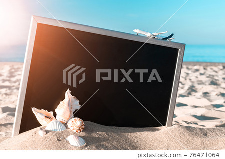 Beach background. Starfish, seashells, toy plane and globe near blackboard on ocean nature beach. Design of summer vacation holiday concept. 76471064