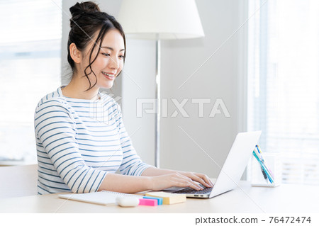 年輕女子在客廳裡做遠程辦公 年輕女子在客廳裡做遠程辦公 76472474