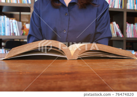 Asian women in library, reading, studying. 76474820