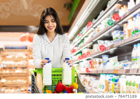 Cheerful Arabic Woman Doing Grocery Shopping Buying Milk In Supermarket Cheerful Arabic Woman Doing Grocery Shopping Buying Milk In Supermarket 76475189