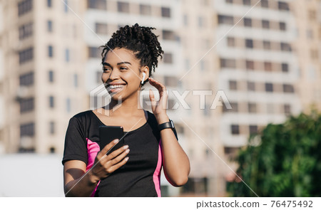 Modern outdoor workout with devices, body care and motivation, music app and jogging Modern outdoor workout with devices, body care and motivation, music app and jogging 76475492