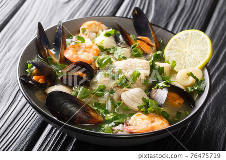 Paila marina is a traditional Chilean stew consisting of a shellfish stock combined with a variety of seafood, shellfish, herbs, spices, and vegetables close-up in a bowl. horizontal Paila marina is a traditional Chilean stew consisting of a shellfish stock combined with a variety of seafood, shellfish, herbs, spices, and vegetables close-up in a bowl. horizontal 76475719