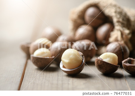Peeled macadamia nuts  on wood background, Macadamia nuts are loaded with flavonoids and tocotrienols and rich in heart-healthy monounsaturated fats 76477031