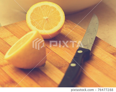 Two limes sitting on top of a wooden cutting board Two limes sitting on top of a wooden cutting board 76477288