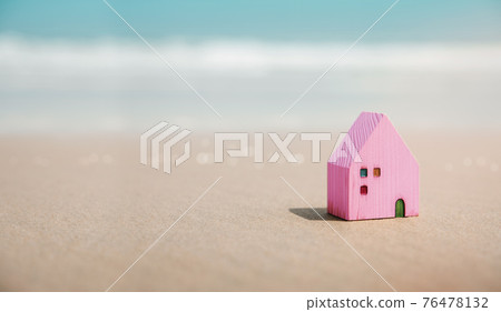 Beach House Concept. Mini Colorful Wooden House on the Sand Beach. Destination for Vacation or Retirement Life. Summer Sunny Day. Metaphor Photo 76478132