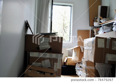 Moving packing concept. Messy Cardboard boxes in a small room with an opened window.  76479267