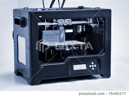 3D printer works and creates an object from the hot molten plastic 76480177